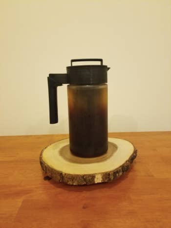 a reviewer's photo of the cold brew maker on a coaster 