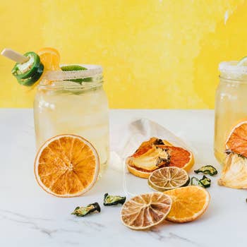 mason jars with margaritas surrounded by dried citrus slices