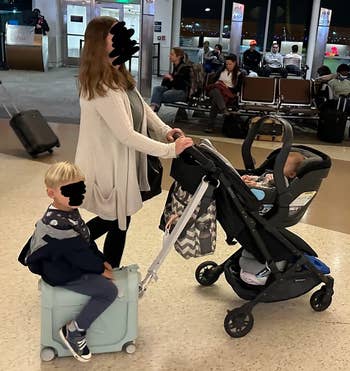 reviewer pushing stroller with child riding on JetKids suitcase attached to the stroller
