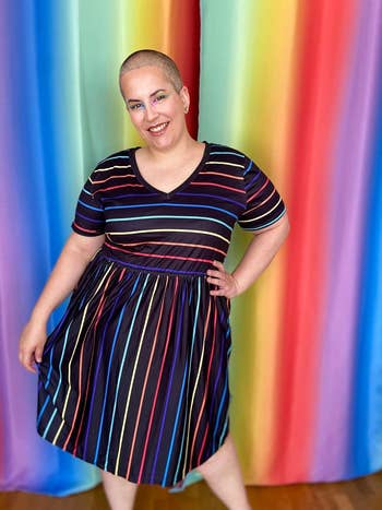 reviewer in a rainbow striped short sleeve dress
