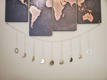 the moon cycle garland displayed on a wall beneath art pieces