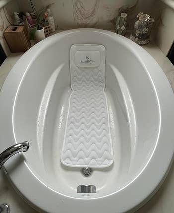 a reviewer photo of the pillow in an empty bath 