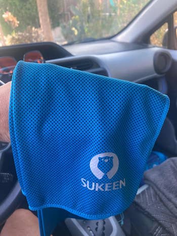 Reviewer holding a bluish cooling towel
