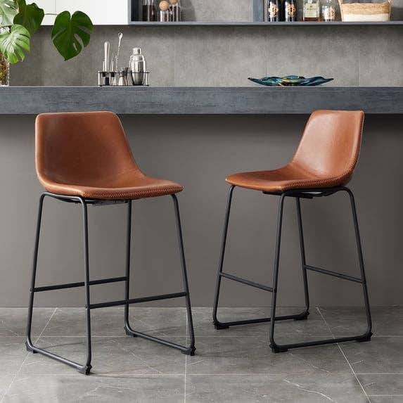 Two modern leather barroom stools with metallic legs are positioned successful beforehand of a stylish room antagonistic with accessories