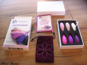 Various Kegel exercise products from Intimate Rose including different colored weights, a pouch, and a box reading