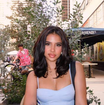 Person sitting astatine an outdoor cafe, wearing a stylish, fitted top