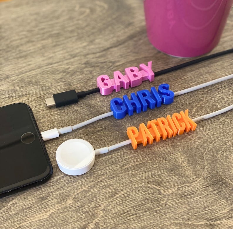 pink, blue, and orange 3d printed name charms on charger cords