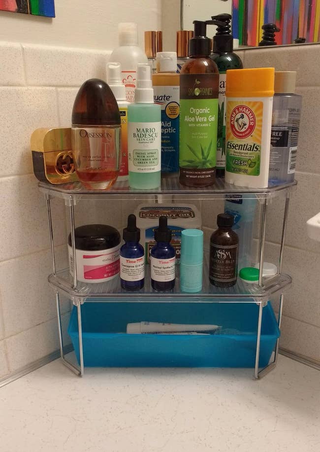 a reviewer photo of the two shelves stacked on one another and filled with toiletries 
