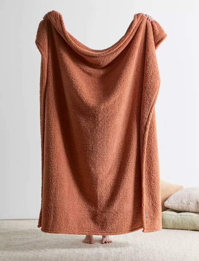 The fleece throw blanket in a rusty copper color