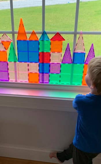 reviewer's child stacking tiles against window