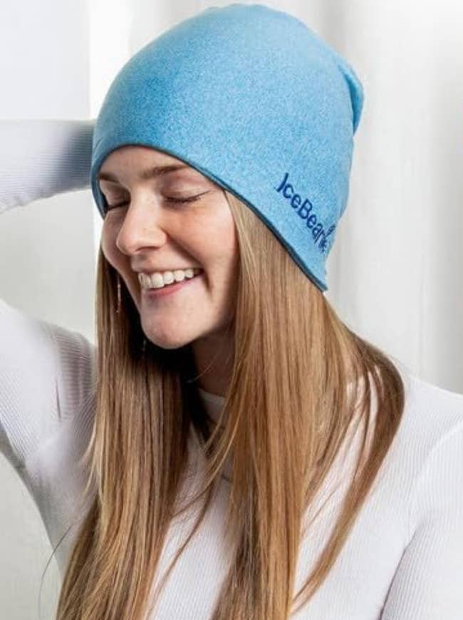 Model wearing blue beanie and smiling 