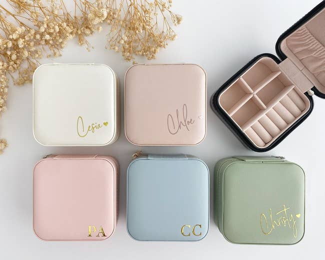 Five small, quadrate jewelry cases, each personalized with names oregon initials, displayed successful a grid with a zippered lawsuit unfastened to amusement compartments. Decorated with flowers