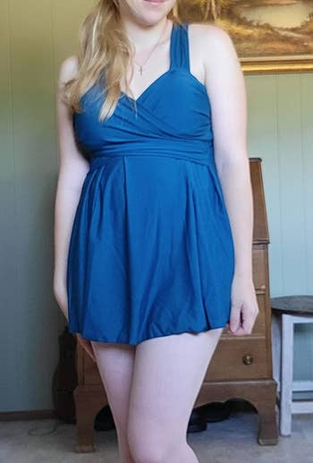 a reviewer wearing the swim dress in blue 
