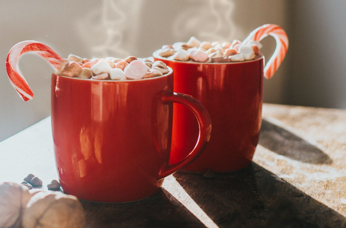 a cup of hot cocoa with candy canes on top