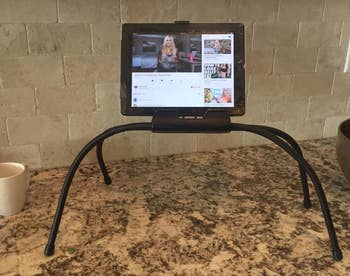the stand on a countertop holding a tablet