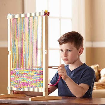 A model using the wooden loom that's sitting on a desk