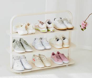 white shoe rack holding nine pairs of sneakers