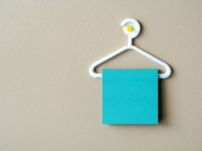 a mini white 3d-printed hanger holding a stack of sticky notes