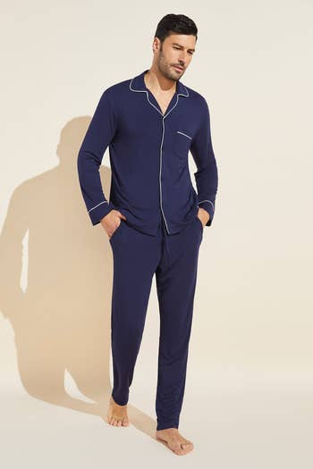 model wearing long sleeved pjs in navy with white-lined collar and sleeves
