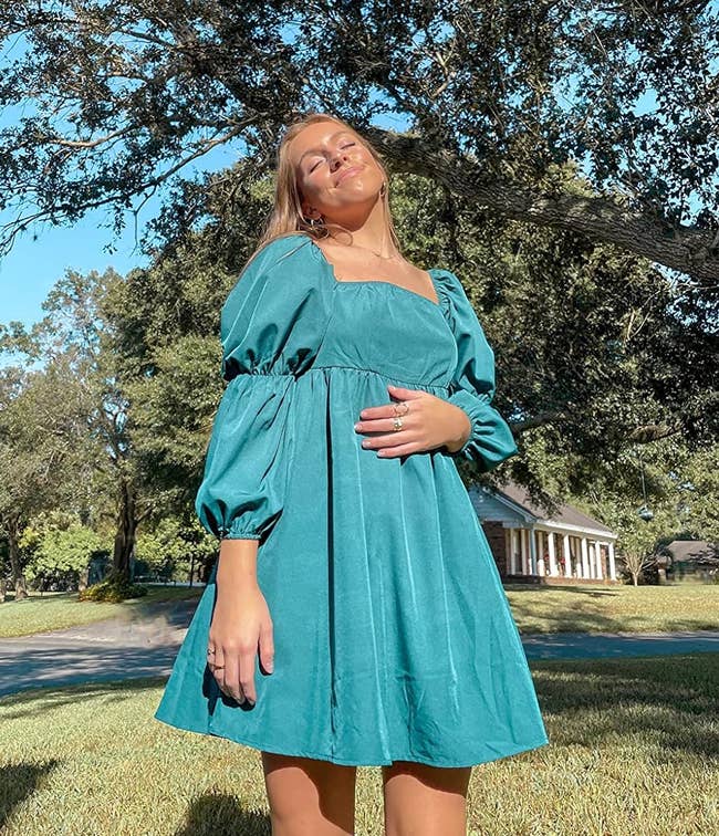 a reviewer wearing the dress in green