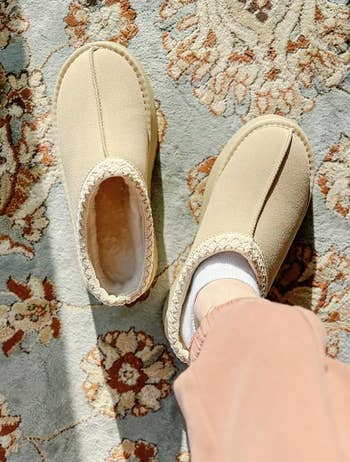 reviewer wearing the beige slippers 