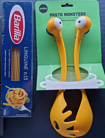 yellow forked ladle and spoon set that both have eyeballs on top of the handle 