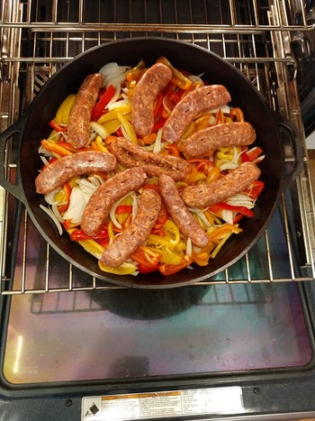 reviewer photo of the skillet full of peppers, onions, and 10 sausages
