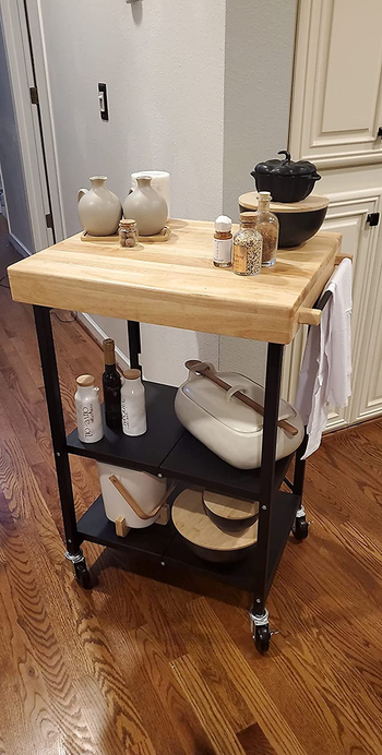 a reviewer photo of the black kitchen cart with a wooden top