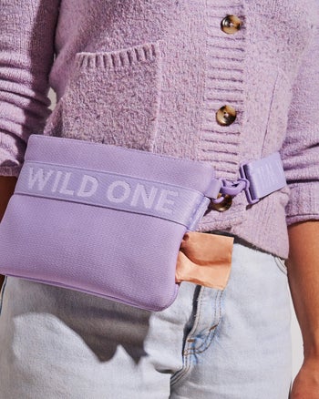 Purple purse strapped to model with matching cardigan