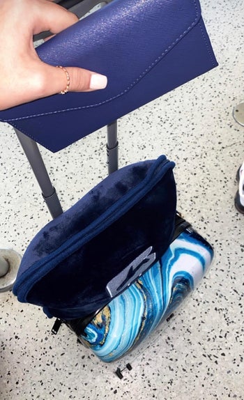 reviewer photo of the blanket in its carrying case attached to a suitcase