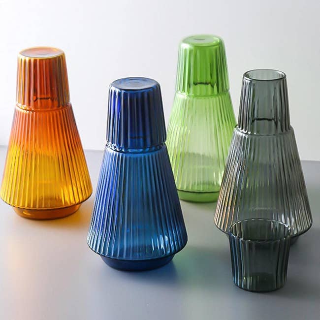 four different color carafes with matching cups