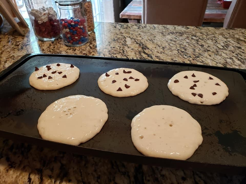 same reviewer's perfectly round pancakes cooking on a griddle, some plain, some with chocolate chips