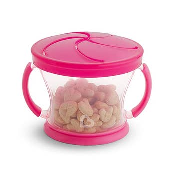 The snack catcher in pink with cereal in it