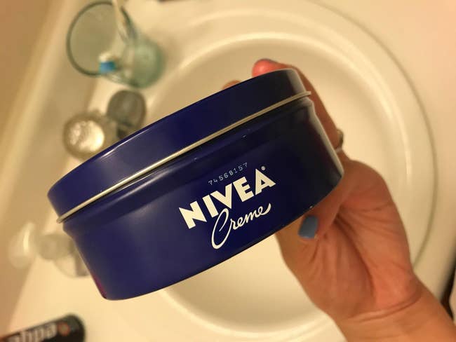 image of reviewer holding up the tin of face and body cream