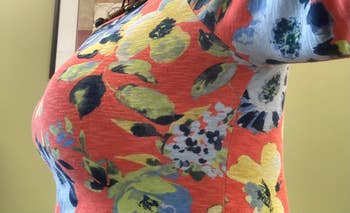 Close-up of a person wearing a floral-patterned top, highlighted the side smoothing effects of a bra