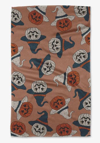 a vintage-y halloween towel with jack-o-lanterns wearing witch's hats