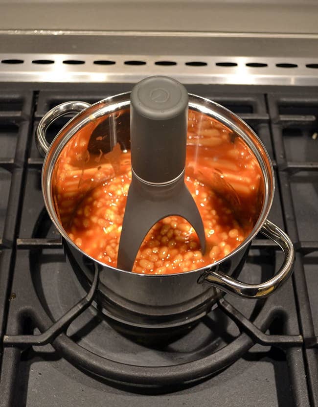 black automatic stirrer stirring a pot of beans