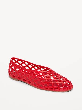 A reddish  mesh slip-on footwear  with a geometric lattice design, suitable for casual wear