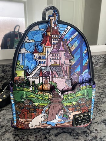 a beauty and the beast backpack with a stained glass design on it