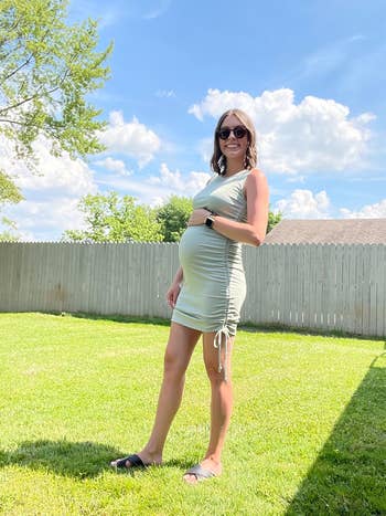 Person successful  a fitted formal  and sunglasses stands connected  grass, smiling