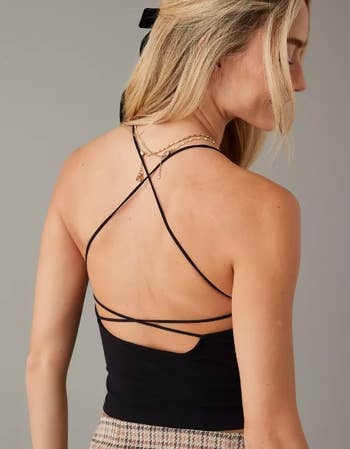 a model showing a crossed thin strap and open back tank top