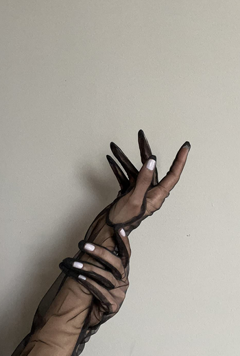 A reviewer showing the black sheer gloves 