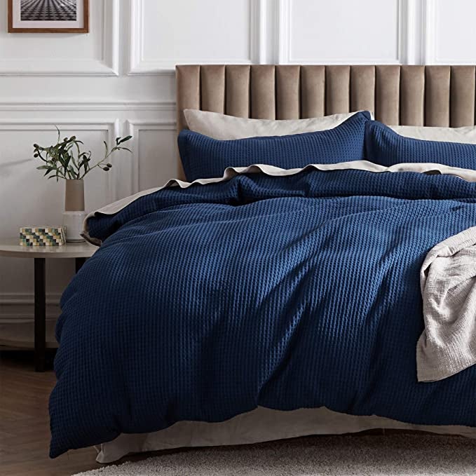 the navy blue waffle woven duvet set on a bed
