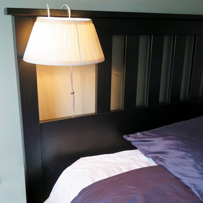 the light with pleated shade slid over a headboard