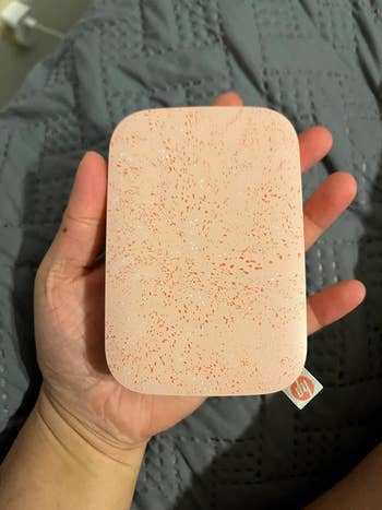 image of the blush pink portable printer in the palm of a reviewer's hand