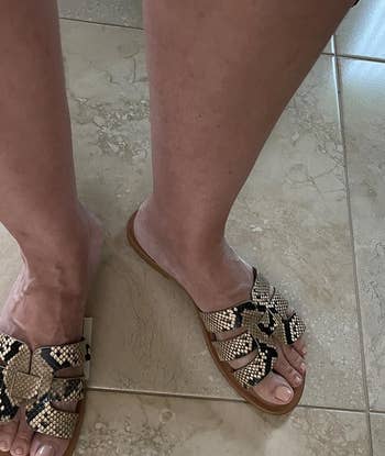 a reviewer wearing the shoes featuring snakeskin print straps