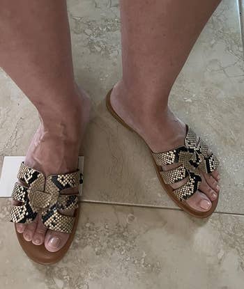 a reviewer wearing the shoes featuring snakeskin print straps