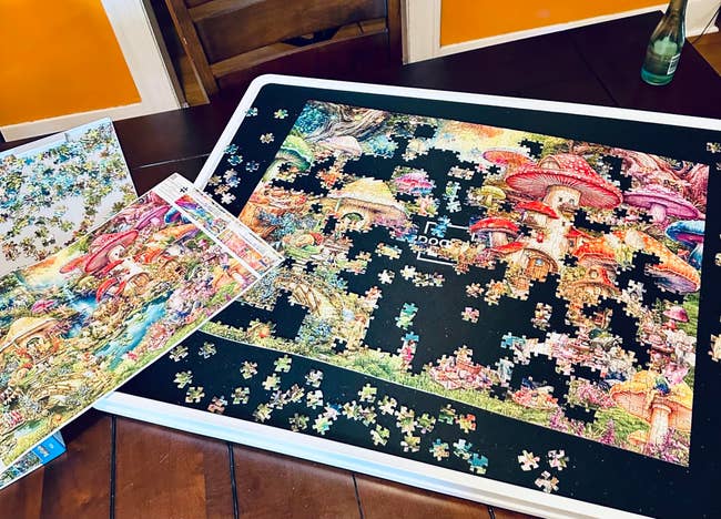 Partially completed mushroom-themed jigsaw puzzle connected a table, with scattered pieces and a notation representation nearby