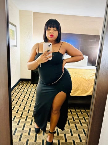 a reviewer in a bodycon maxi dress with a high slit