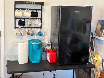 The mini fridge sitting connected  a table